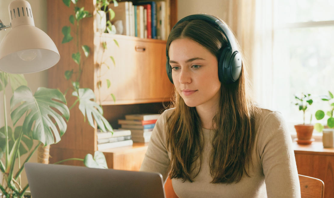 девушка в наушниках за ноутбуком